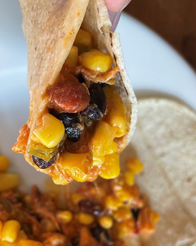 Buffalo style shredded chicken, Mexi-bean mixture (black beans, pinto beans, green bell pepper, onion, mild salsa), shredded cheddar cheese, two white corn tortillas and cut corn